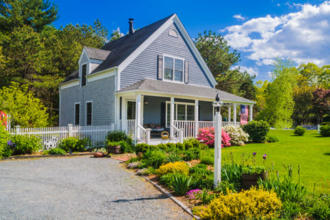 Exterior of a two story home with bright green grass and clear blue sky