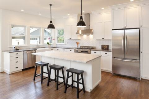 Newly renovated kitchen with white cabinets and countertops and stainless steel appliances