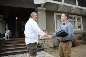 MightyMite Termite Services technician meeting a homeowner for professional termite pest control.
